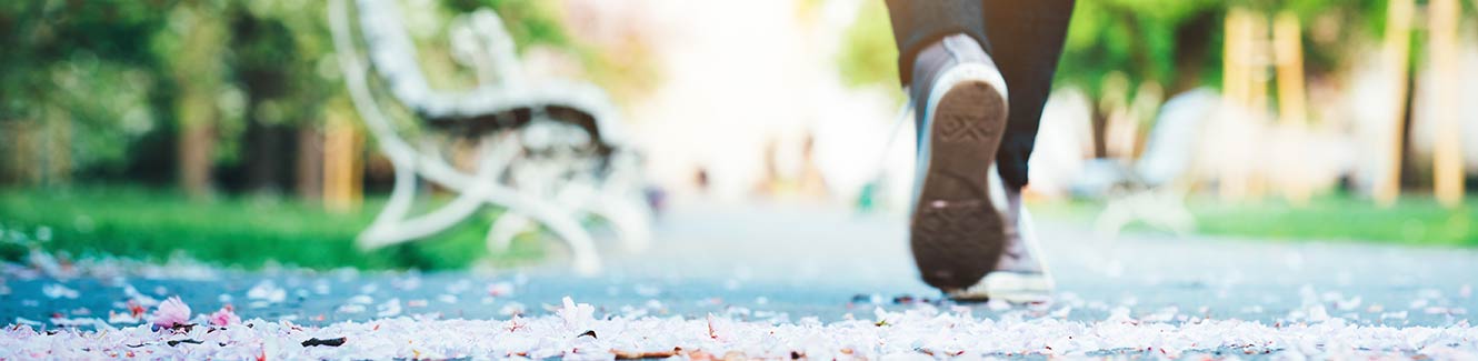 Person walking down a sidewalk in the fall.