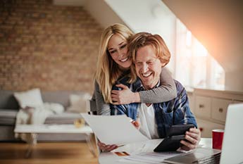 Husband and wife going over finances and smiling